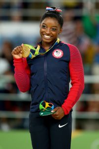 RIO DE JANEIRO, BRAZIL - AUGUST 16: Gold medalist Simone Biles of the United States celebrates on the podium at the medal ceremony for the Women's Floor on Day 11 of the Rio 2016 Olympic Games at the Rio Olympic Arena on August 16, 2016 in Rio de Janeiro, Brazil. (Photo by Alex Livesey/Getty Images)
